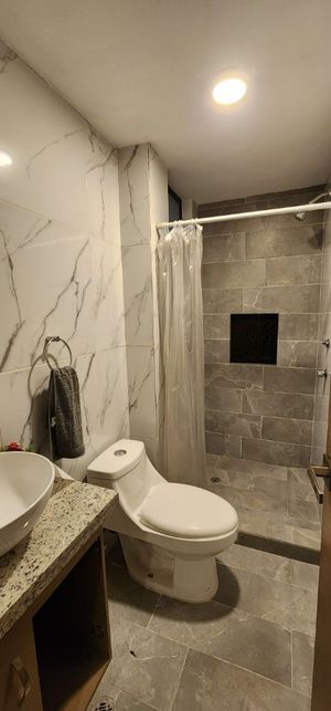 Baño completo con mosaico en paredes y lavamanos de ceramica