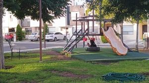 Juegos infantiles con areas verdes, asador y palapa.